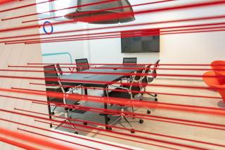 Installazione a parete di alcuni fili da cui si intravede un tavolo per il coworking.